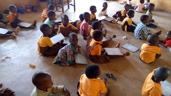 Kindergarten pupils of the school sitting on the floor during class